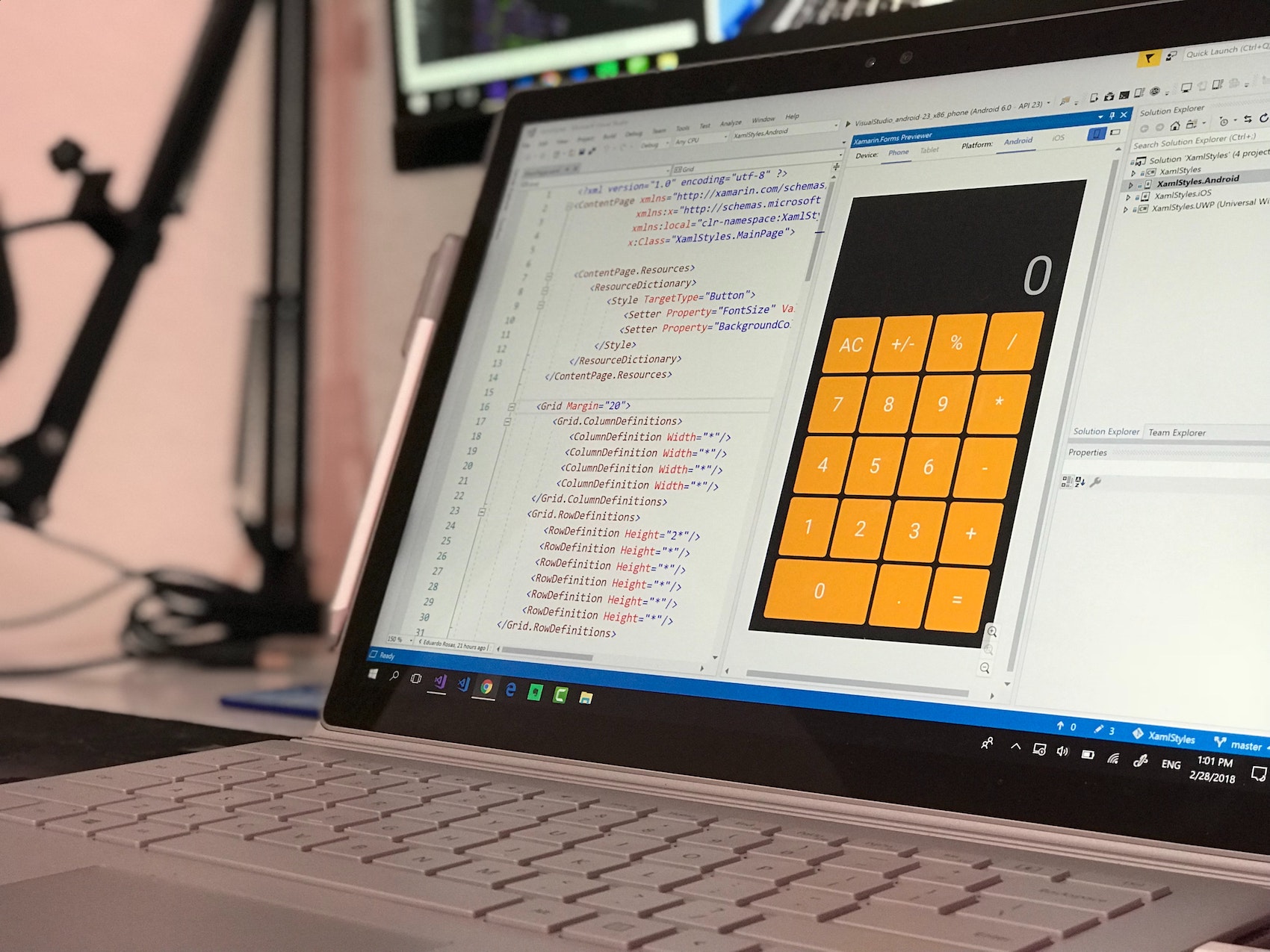 An iPhone app developer usi g VS Code to write codes for an iPhone styled calculator app on a Windows Laptop